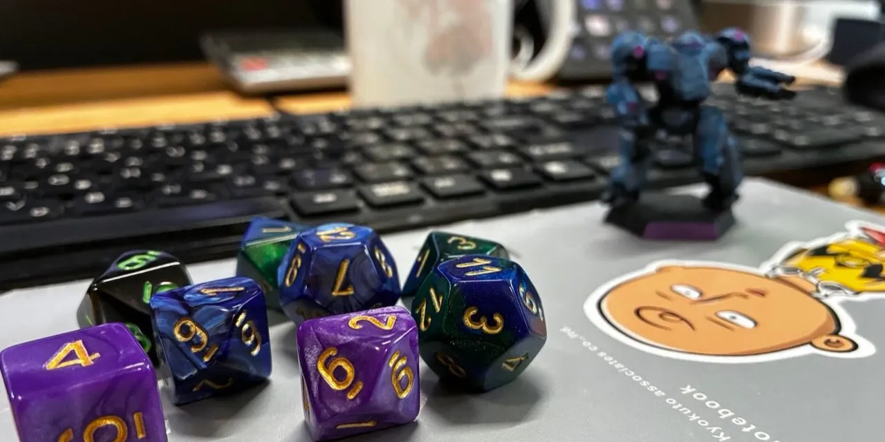Polyhedral dice and a painted mech miniature on a desk